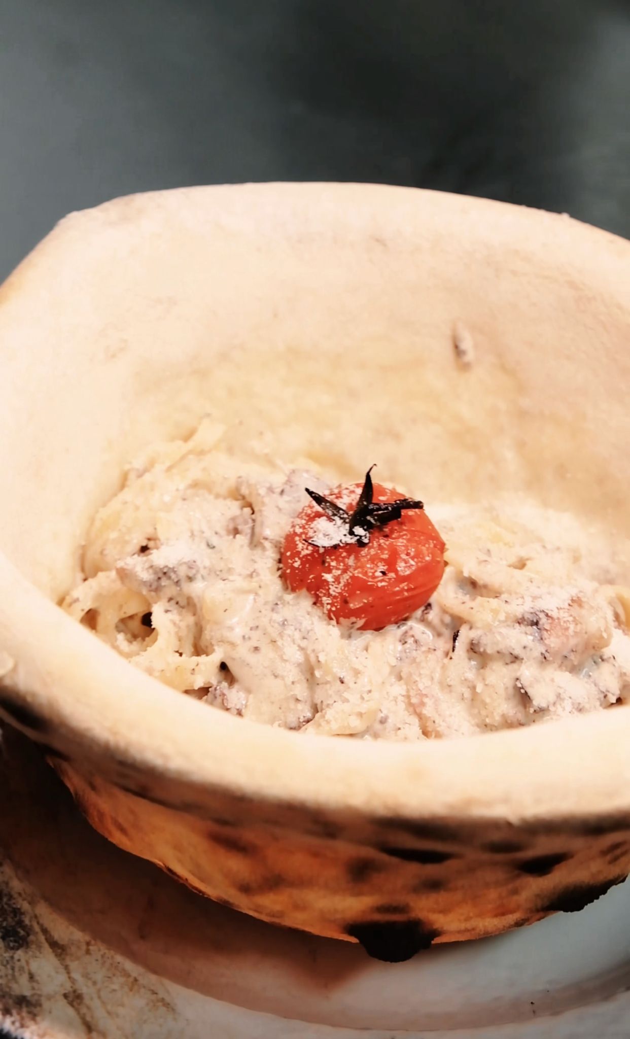 Cremige Pasta in einer essbaren Pizzaschale
